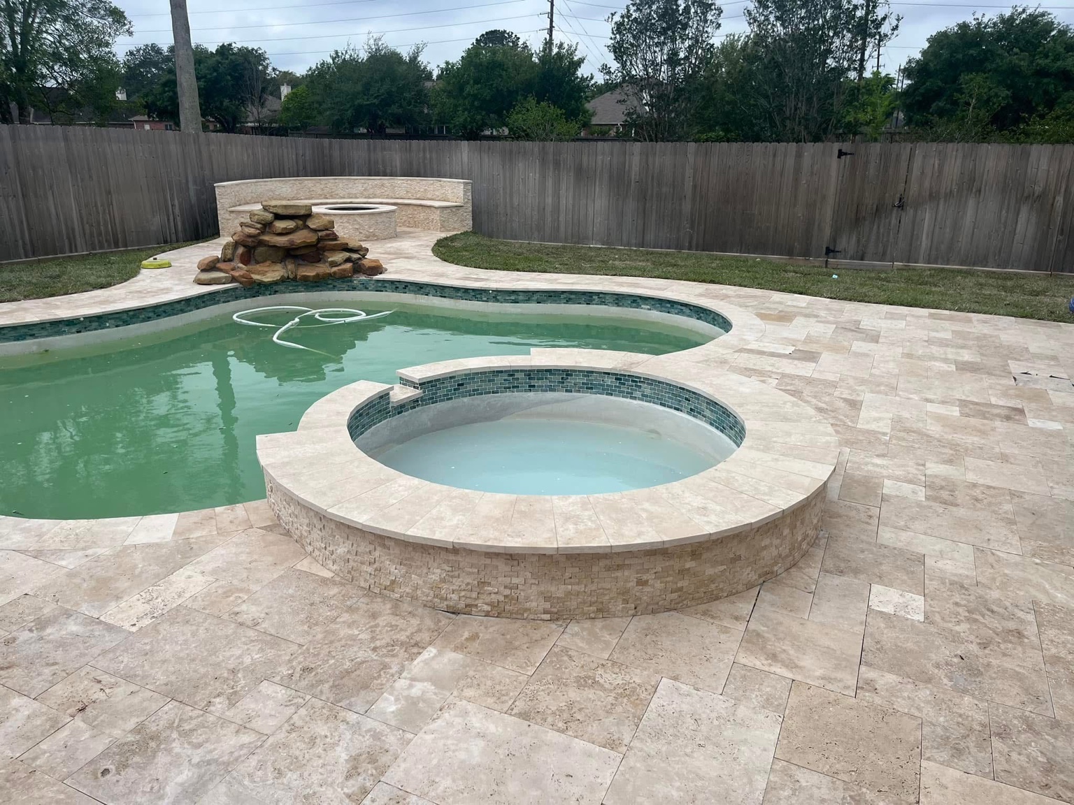After view of a renovated Katy pool with natural stone decking, coping and finished spa surround