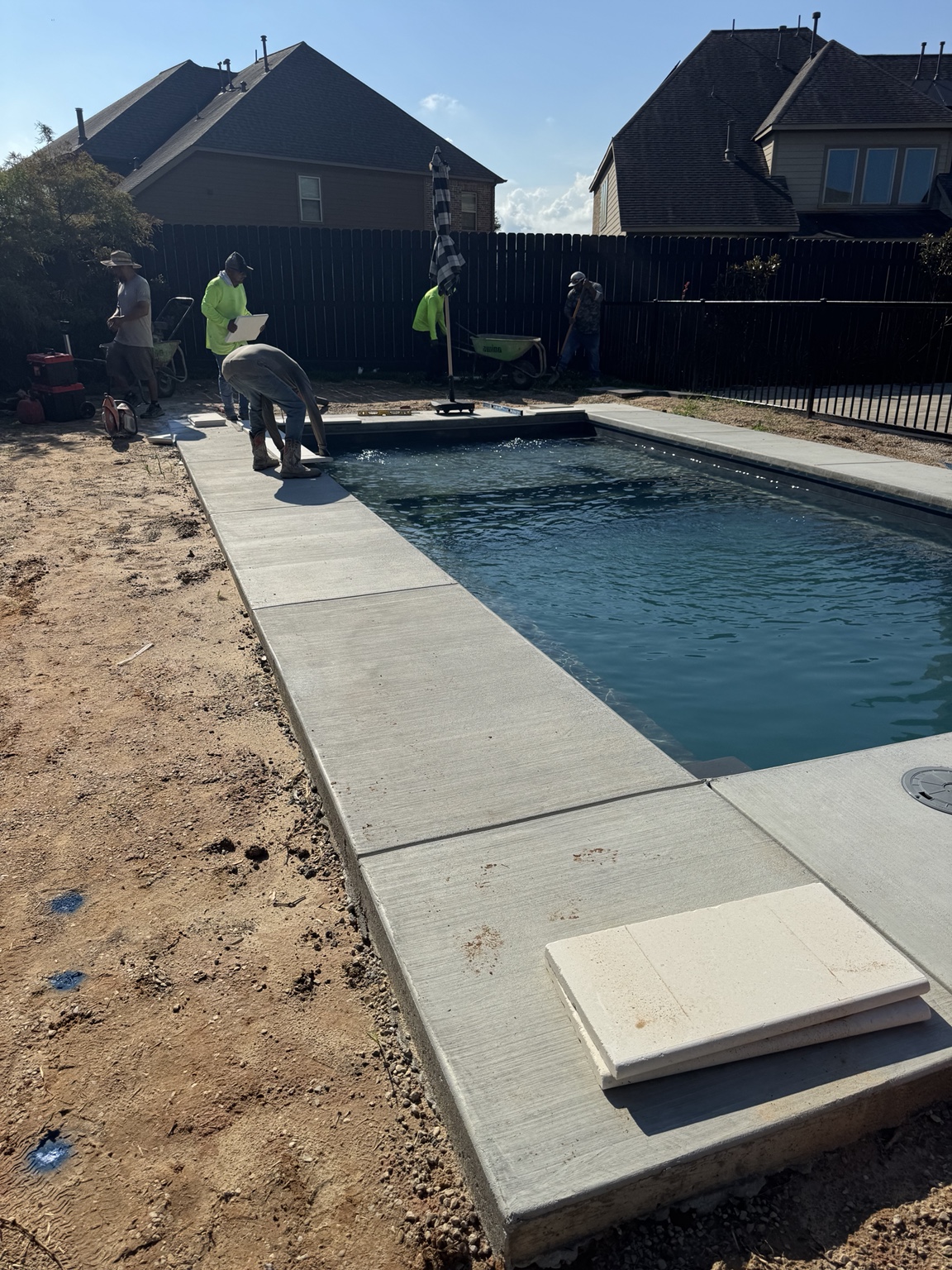 Before view of a swimming pool with a plain concrete deck during construction